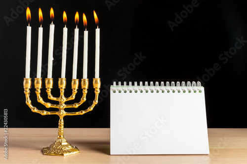 Bronze Hanukkah menorah with burning candles