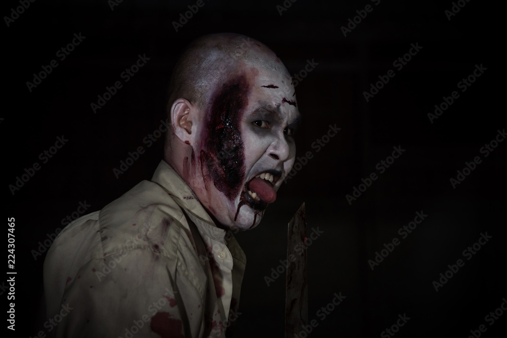 Male zombie holding knife in dark room
