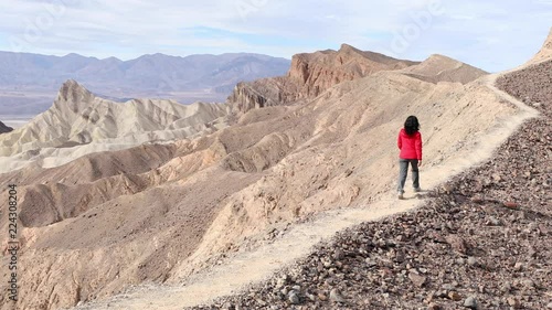 Asian woman hikiing along a ridgeline in Death Valley California.