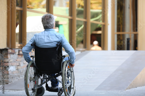 Senior man in wheelchair near ramp outdoors