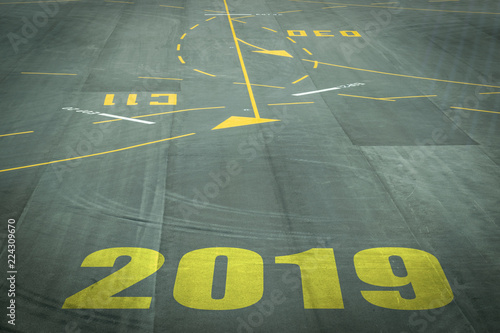 Closeup 2019 figures on the surface of the airport runway texture background.