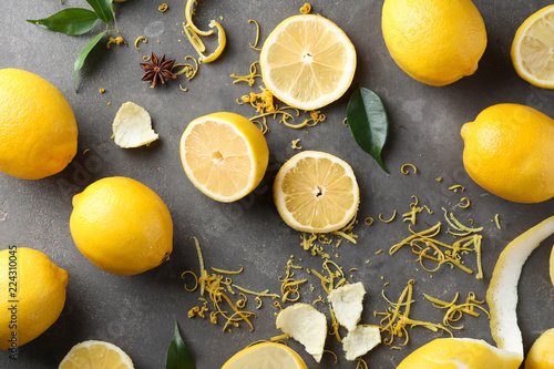 Tableau sur toile Composition with ripe lemons and fresh zest on grey background
