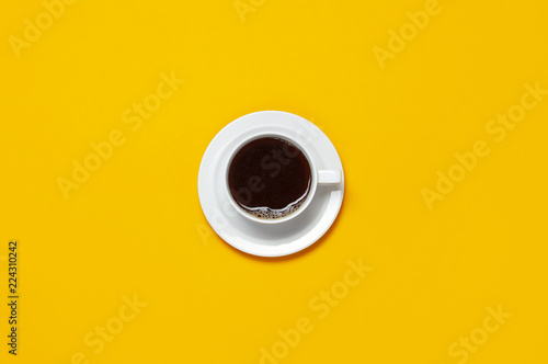 Cup of coffee on bright yellow minimalistic background, top view Flat Lay with copy space. Creative concept of eating, drink, morning