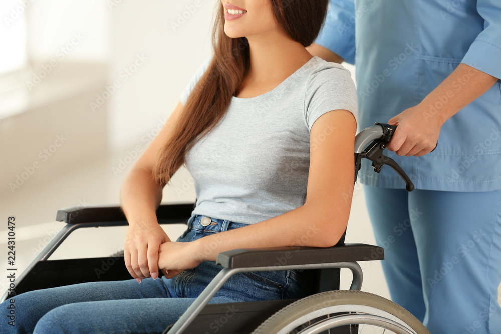 Handicapped young woman with mature female doctor in clinic