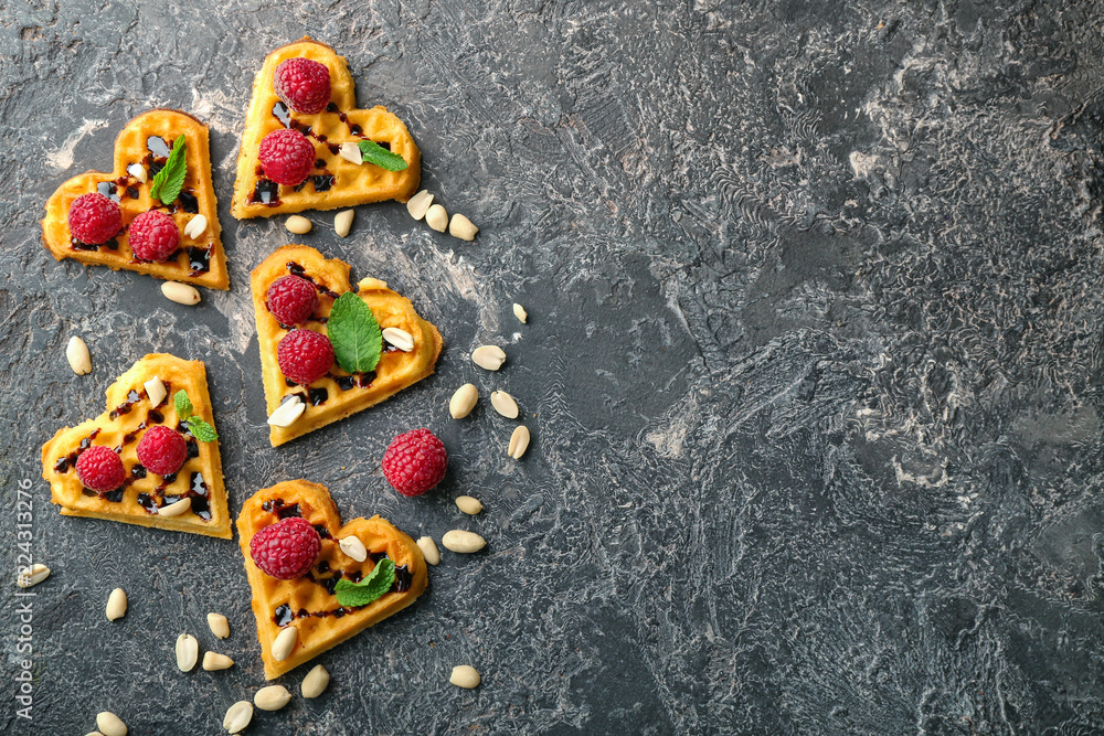 Heart shaped waffles with raspberries and nuts on grey background Heart shaped waffles with raspberries and nuts on grey background
