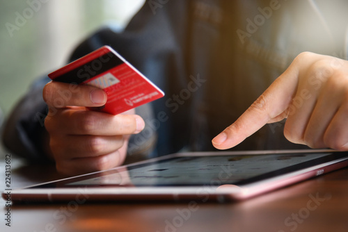 Online payment,woman's hands holding credit card and using tablet for online shopping. Cyber Monday Concept