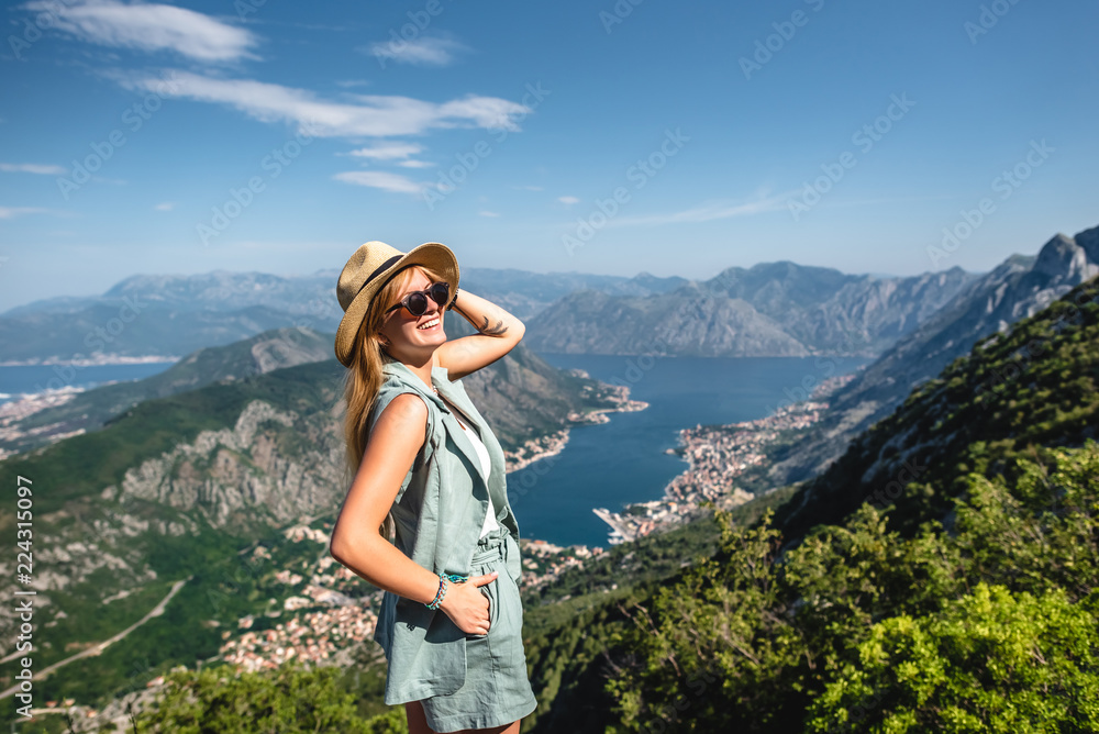 smiling woman posing with beautiful view on Kotor bay in Montenegro