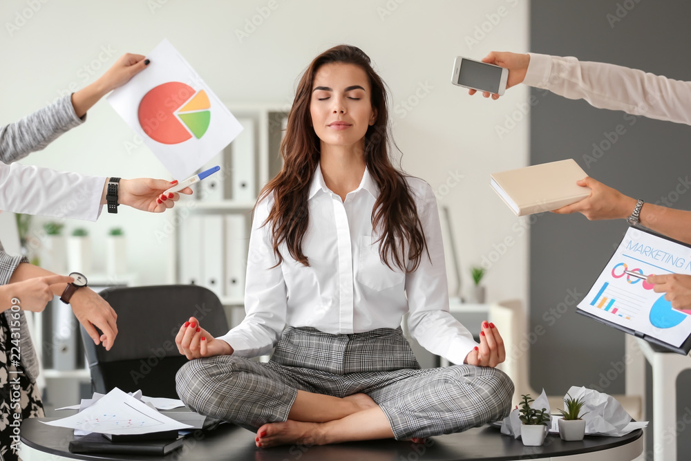 Businesswoman with a lot of work to do meditating in office Stock-foto | Adobe Stock