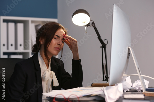 Tired woman working late in...