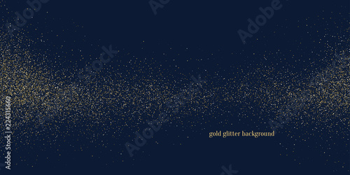 Gold glitter. Shiny particles on a dark background.