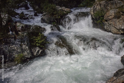 A mountain stream flows with its impetuous waters between the rocks