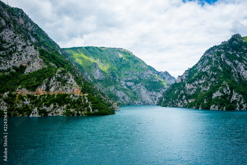 Calm blue water of Piva Lake (Pivsko Jezero) and mountains in Montenegro