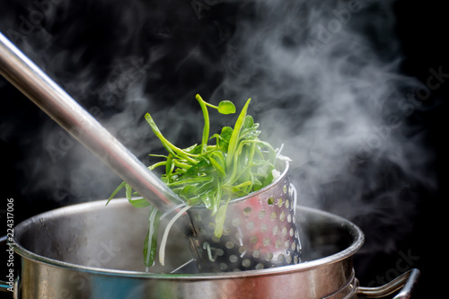 Noodle blanched in basket with hot smoke and steam. photo