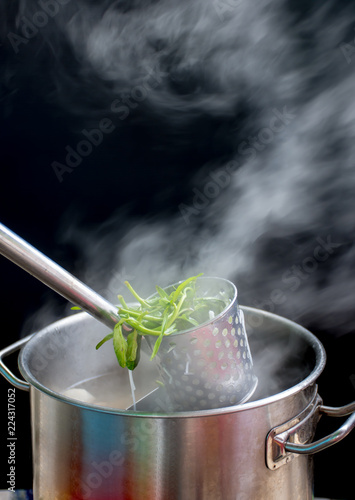 Noodle blanched in basket with hot smoke and steam. photo