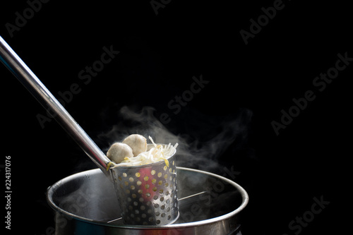 Noodle blanched in basket with hot smoke and steam.