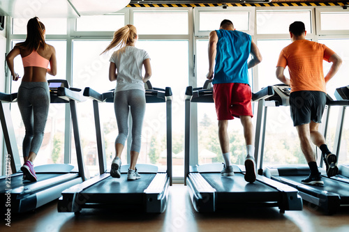 Happy people on treadmills in the gym