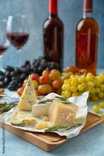 Different types of cheese with rosemary on wooden board