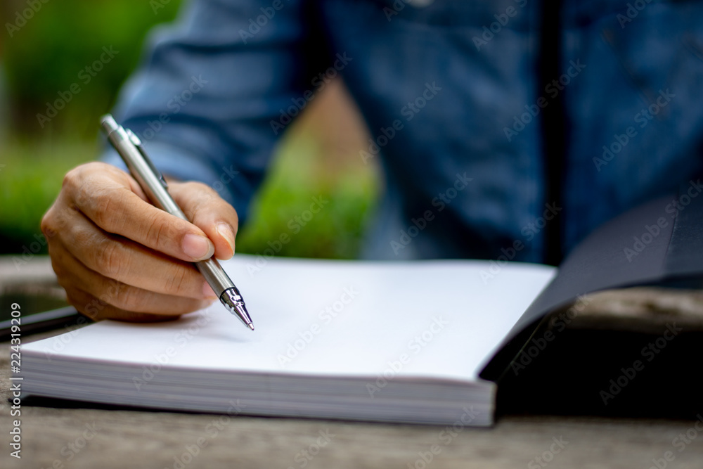 Young woman hand holding pen writing on blank notebook and concentrate on reading book with copy space in free time. Knowledge concept. Young woman hand holding pen writing on blank notebook and concentrate on reading book with copy space in free time. Knowledge concept.