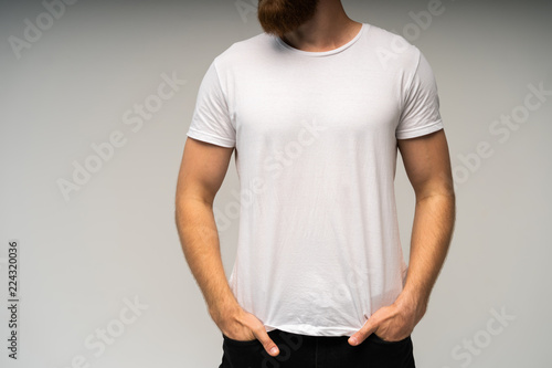 Young man wearing blank white t-shirt isolated on white background. Copy space. Place for advertisement. Front view.