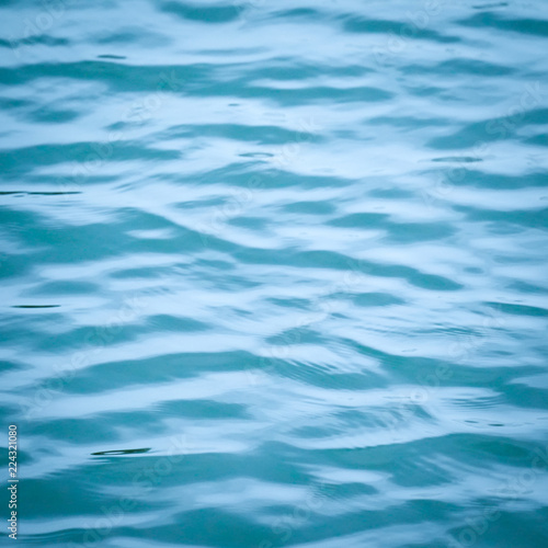 blue water surface background texture blurred light with wave ripple nature abstract. © arwiyada