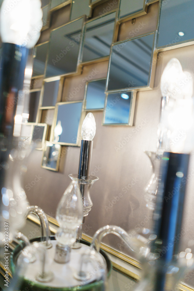 Detail design and interior lighting - white metal wall lamp in the form of candlesticks and candles. Detail design and interior lighting - white metal wall lamp in the form of candlesticks and candles.