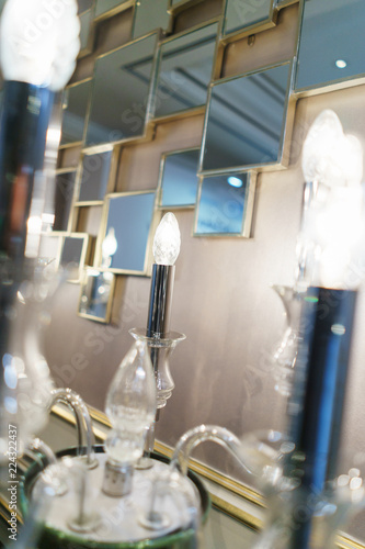 Detail design and interior lighting - white metal wall lamp in the form of candlesticks and candles. © Evgenii Starkov
