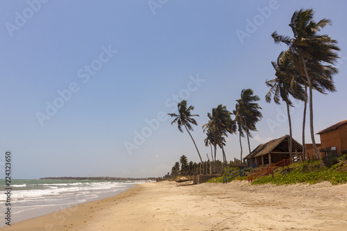 Cottages and palm trees on Sankofa beach Ghana, near Accra city photo