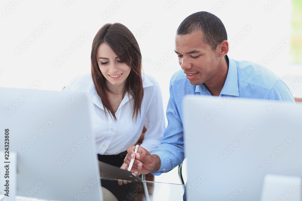 employees discussing financial documents sitting at a Desk employees discussing financial documents sitting at a Desk