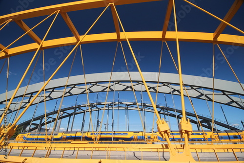 Photography Bright yellow bridge named Hogeweidebrug over the Amsterdam-Rhine canal in Utrec