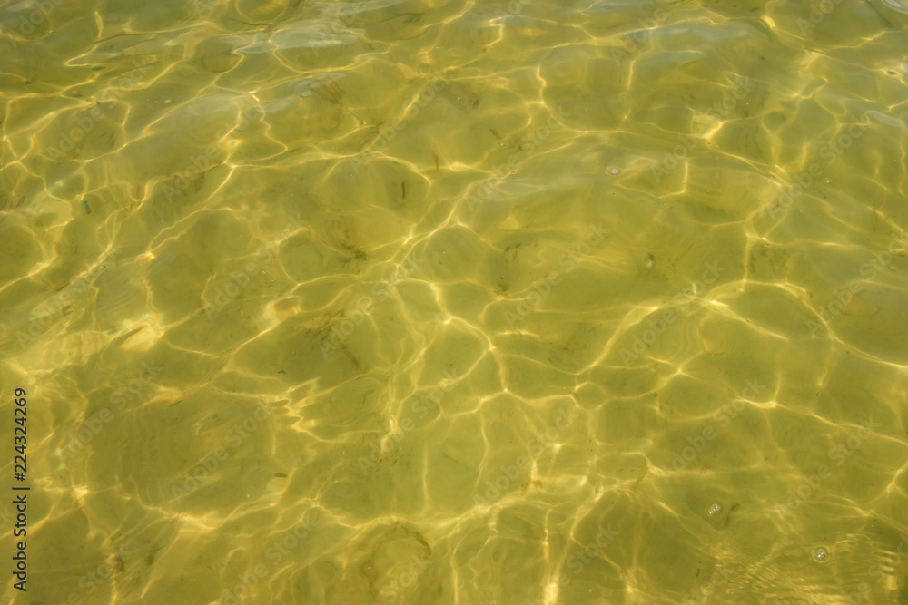 Waves and glare on the surface of the water. Shallow. Lake. Background