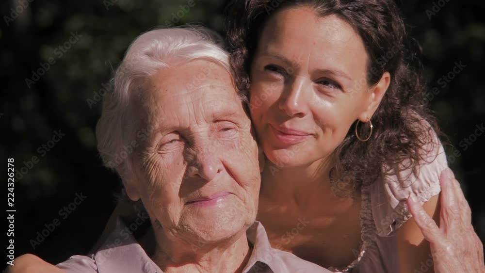 Portrait of a happy family. A woman is hugging an elderly mother. Granddaughter embraces his grandmother. Portrait of a happy family. A woman is hugging an elderly mother. Granddaughter embraces his grandmother.