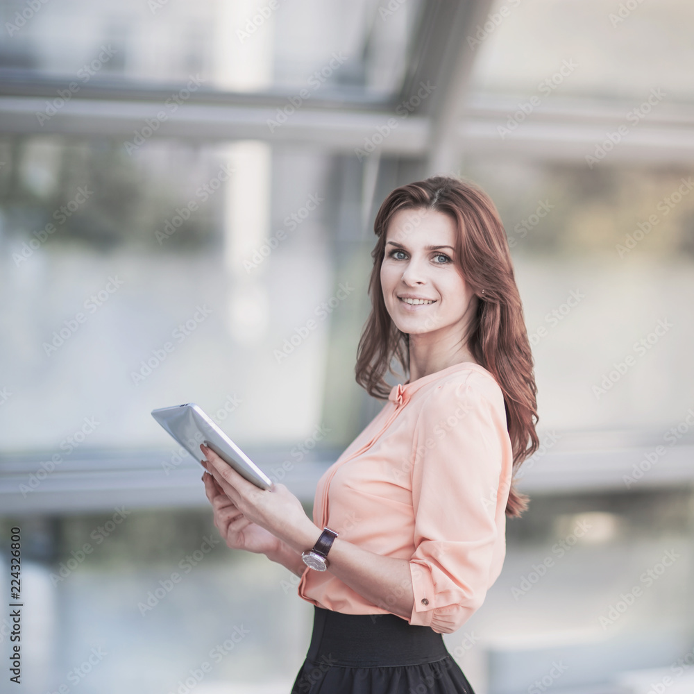 successful business woman with digital tablet standing in the lobby of a modern office successful business woman with digital tablet standing in the lobby of a modern office