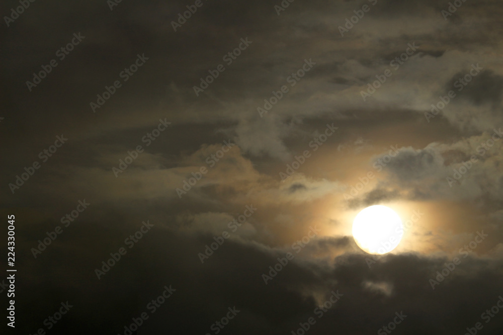 A sun similar to the full moon seen from the cloudy sky