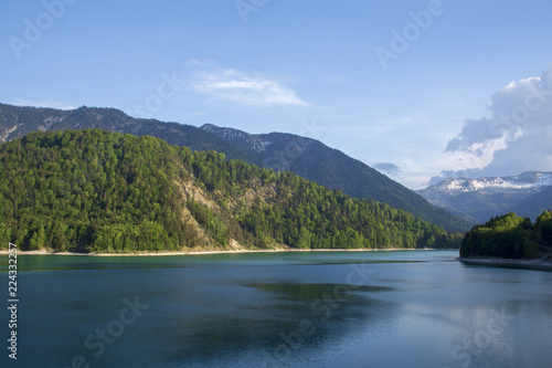 View over lake Sylvenstein with alps and a blue sky in background