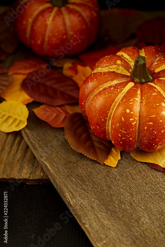 Autumn leaves and pumpkin wooden