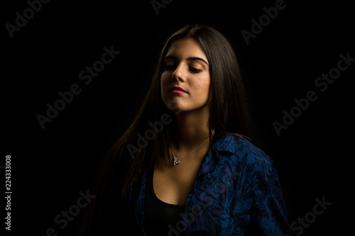 young brunette girl with long straight hair posing, black background