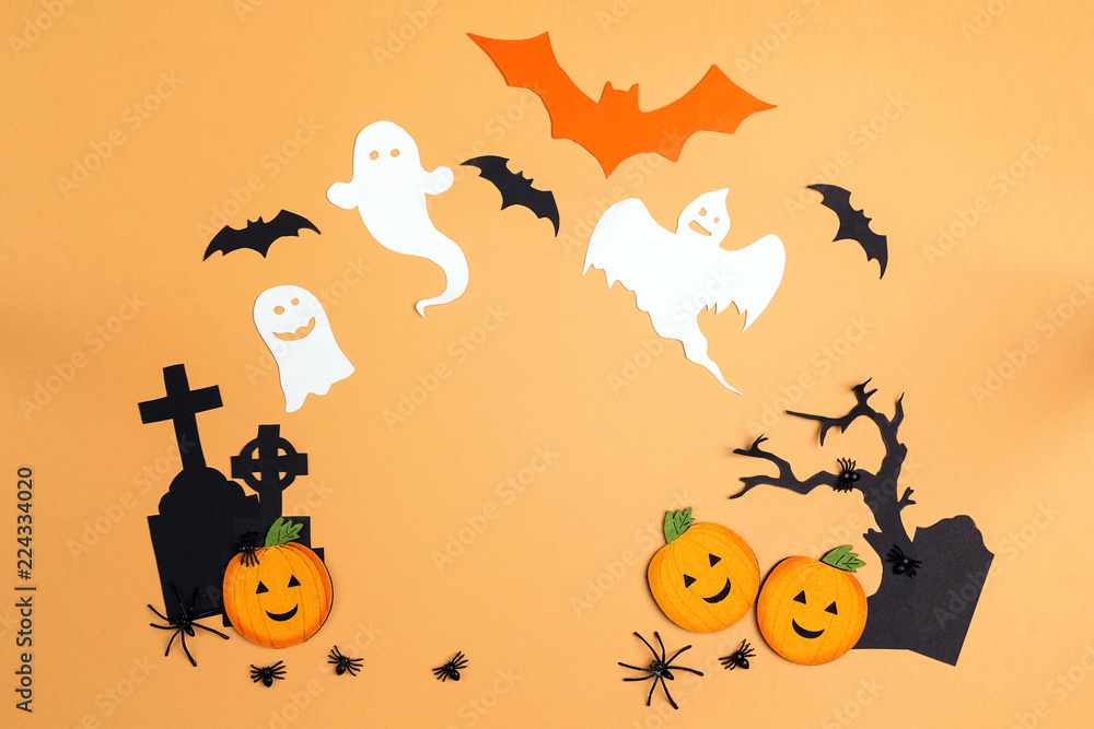 Flat lay Halloween background with cartoon cemetery, pumpkins and ghosts.