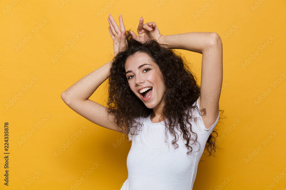 Cute young woman posing isolated over yellow background. - obrazy, fototapety, plakaty 