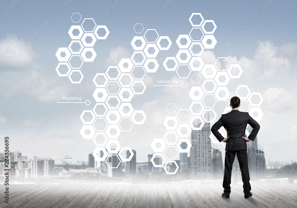 Pensive businessman looking at user interface against modern city background Pensive businessman looking at user interface against modern city background