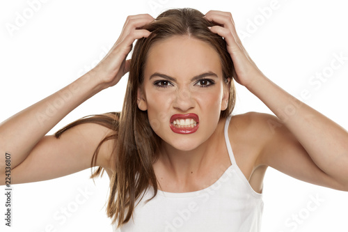 Beautiful nervous girl with itch on her scalp on white background