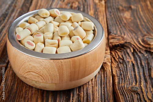 Bowl of commercial doggy biscuits sausage rolls photo