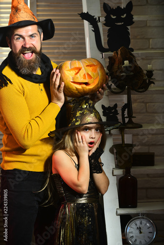 Little kid and man with halloween pumpkin. Bearded man and little kid celebrate halloween. Trick or treat. Tonight is halloween