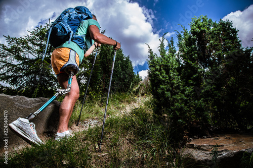 Low angle of a motivated man with prosthesis walking up