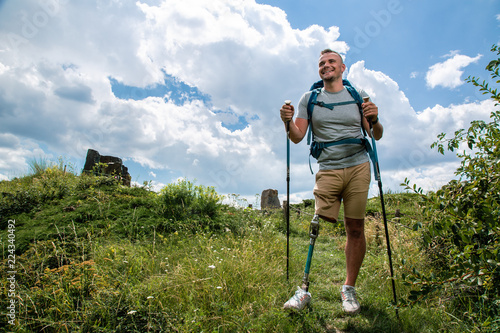 Full length of an optimistic man with prosthesis enjoying Nordic walking