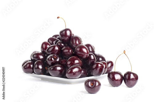 Cherries on a white plate on a white background isolated closeup macro