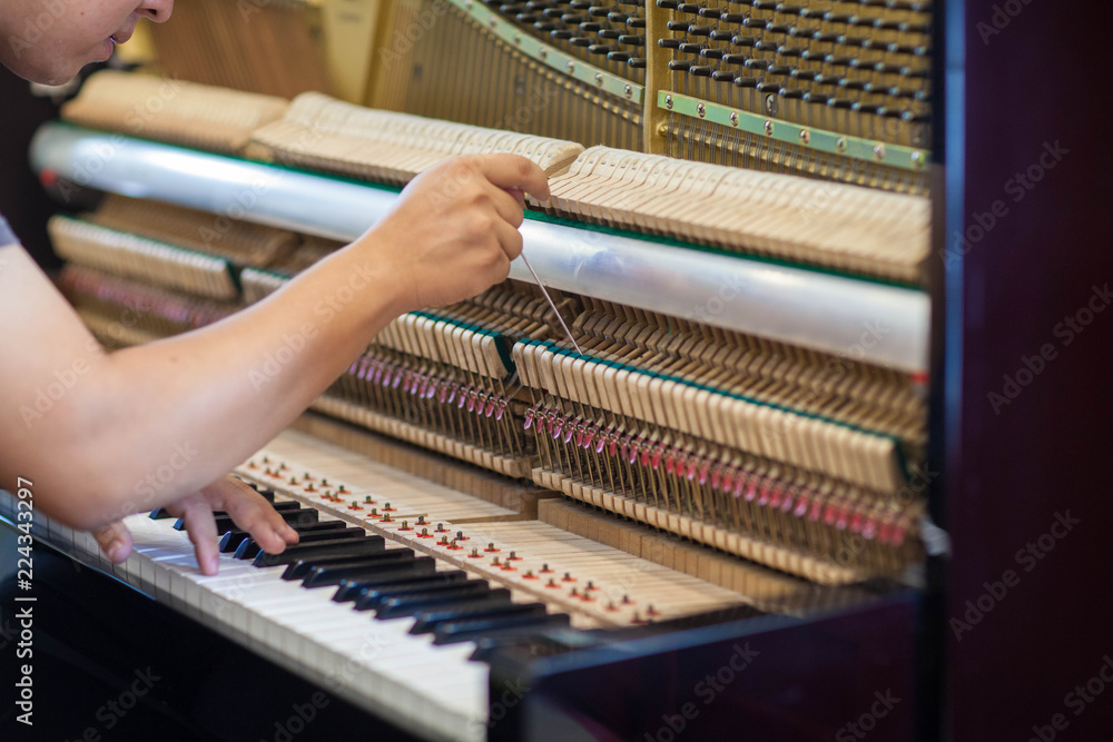 Piano repairers or musicians are repairing and customizing the piano.