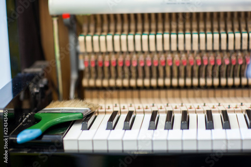 Piano repairers or musicians are repairing and customizing the piano.