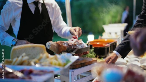Catering table with food and hands of people in Restaurant outdoor. People group catering buffet food. Food service worker