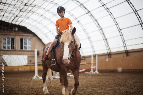 Boy in helmet learning Horseback Riding © olsima