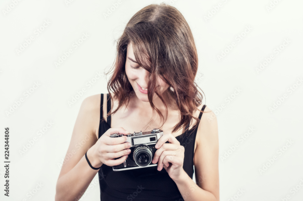 beautiful young girl in a short black dress takes pictures with an old vintage camera, a smile, a beautiful face, a brunette. beautiful young girl in a short black dress takes pictures with an old vintage camera, a smile, a beautiful face, a brunette.